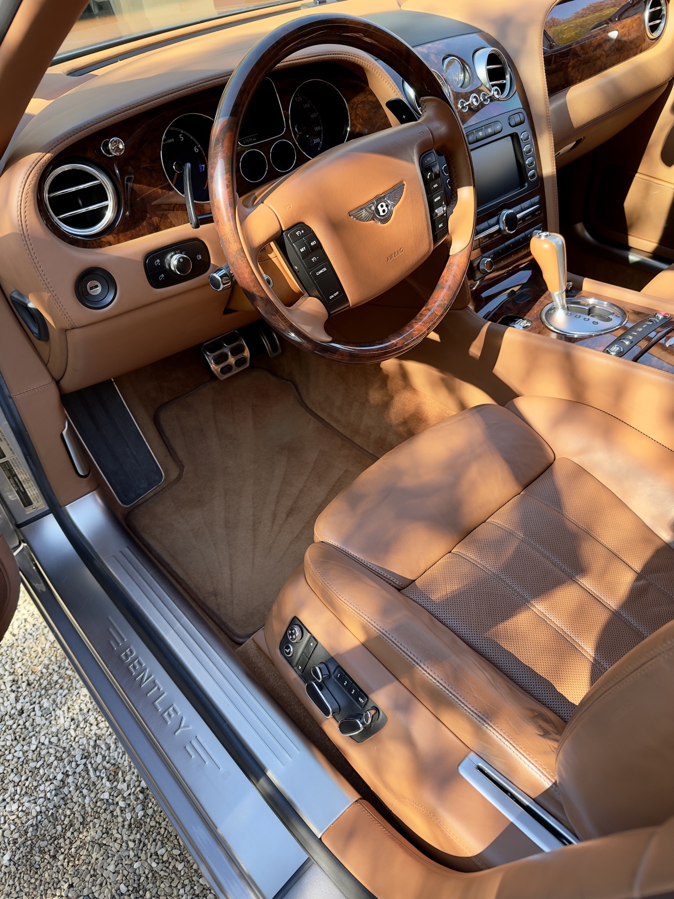 Bentley Continental driver cockpit with tan leather and wood steering wheel