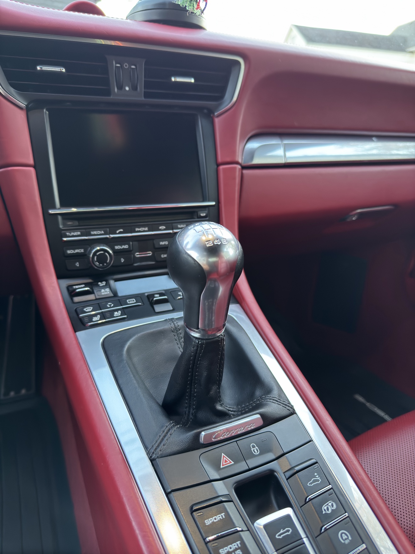 Close-up of the manual shifter in a Porsche 911 Carrera S with red interior