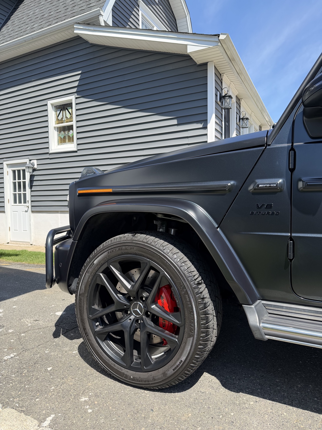 Close-up of the AMG wheel with red brake caliper on the matte black G 63