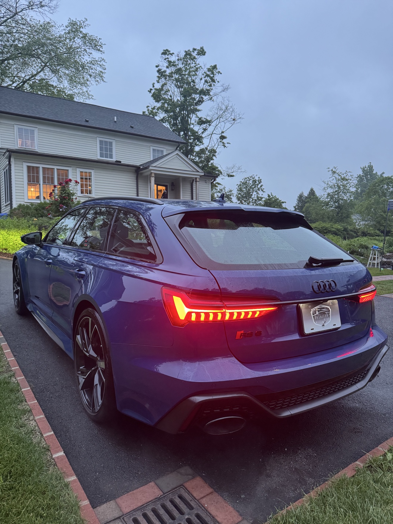 Blue Audi RS6 Avant rear angle view with glowing taillights