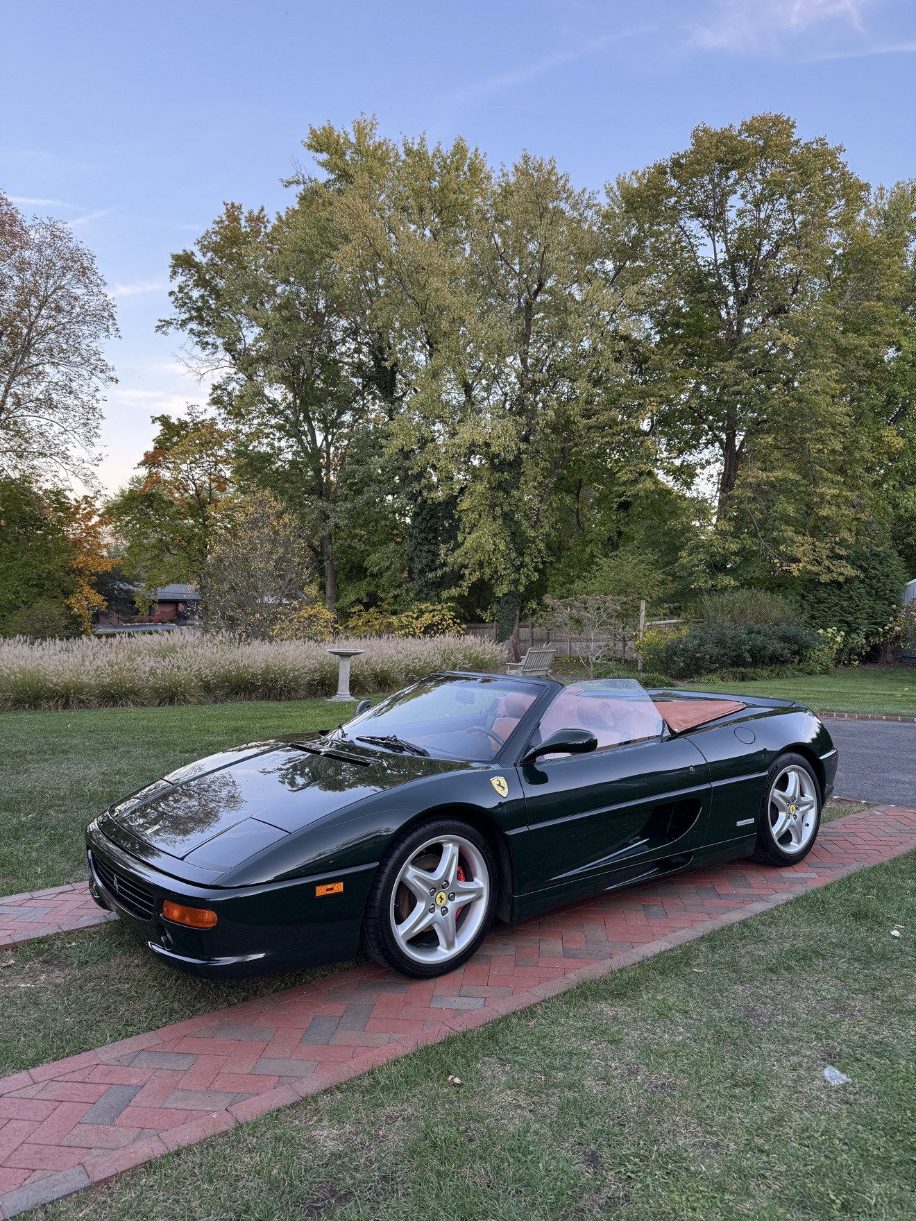 Dark green Ferrari F355 Spider after detailing on a brick driveway