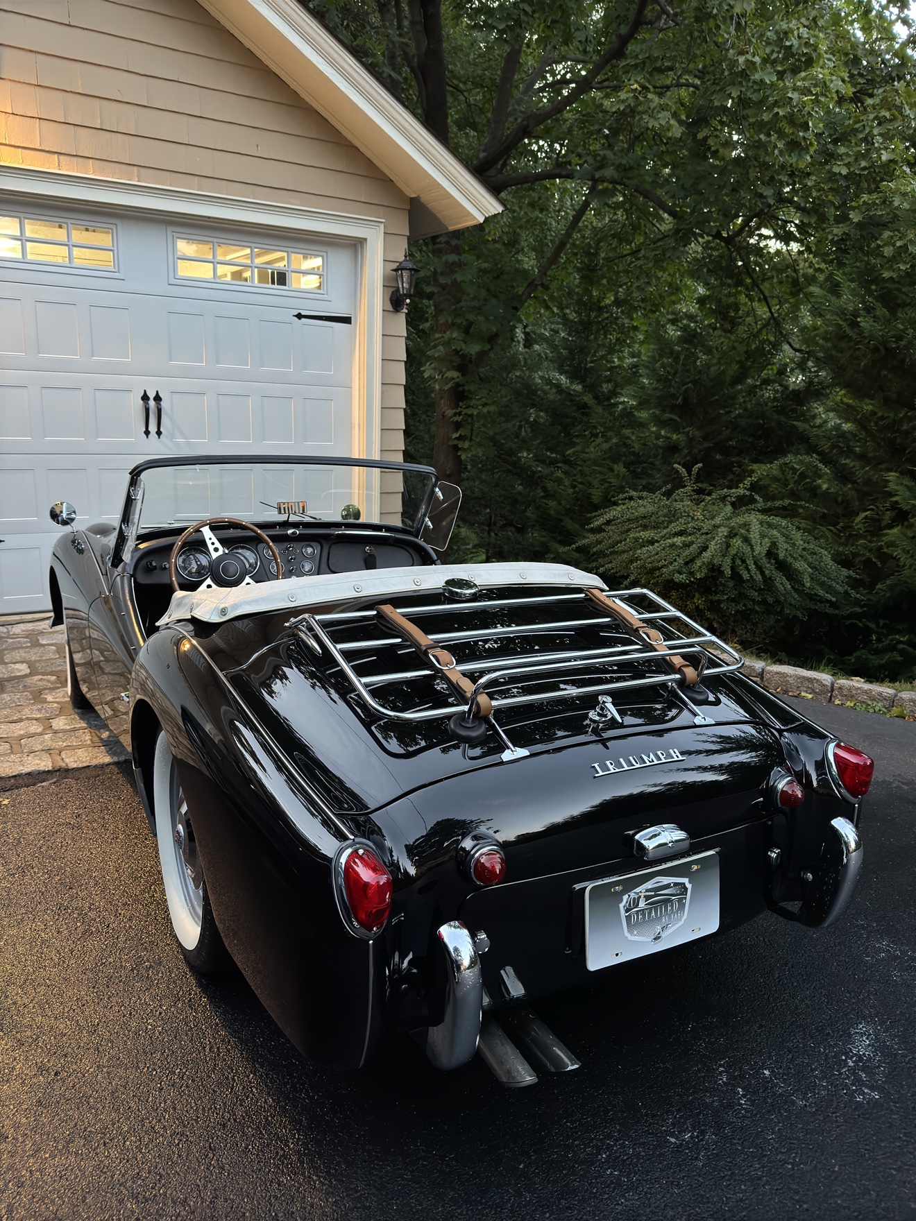 Black Triumph TR3 rear three-quarter view with luggage rack after detailing