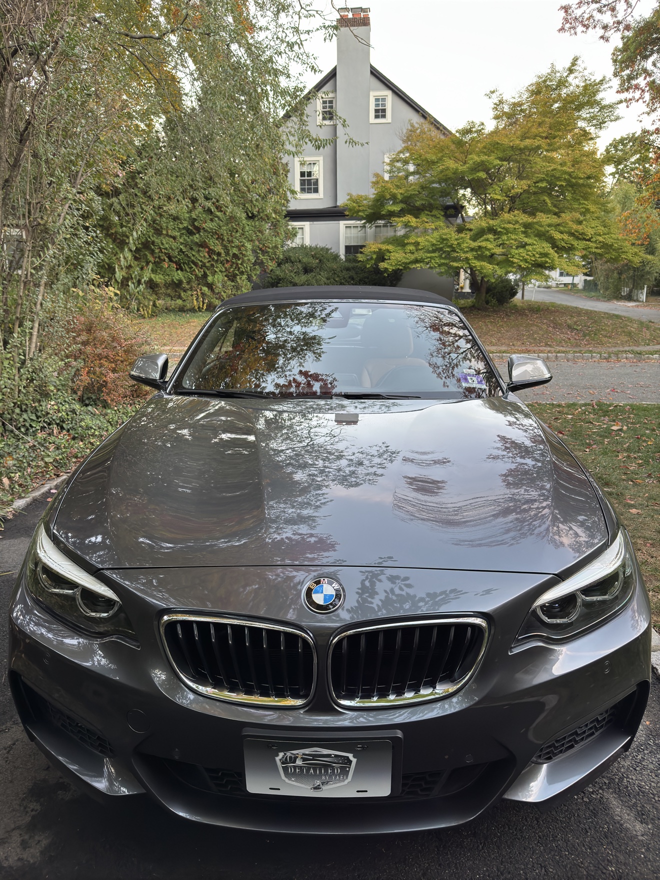 Front view of a gray BMW M240i convertible with Detailed by Yael plate frame