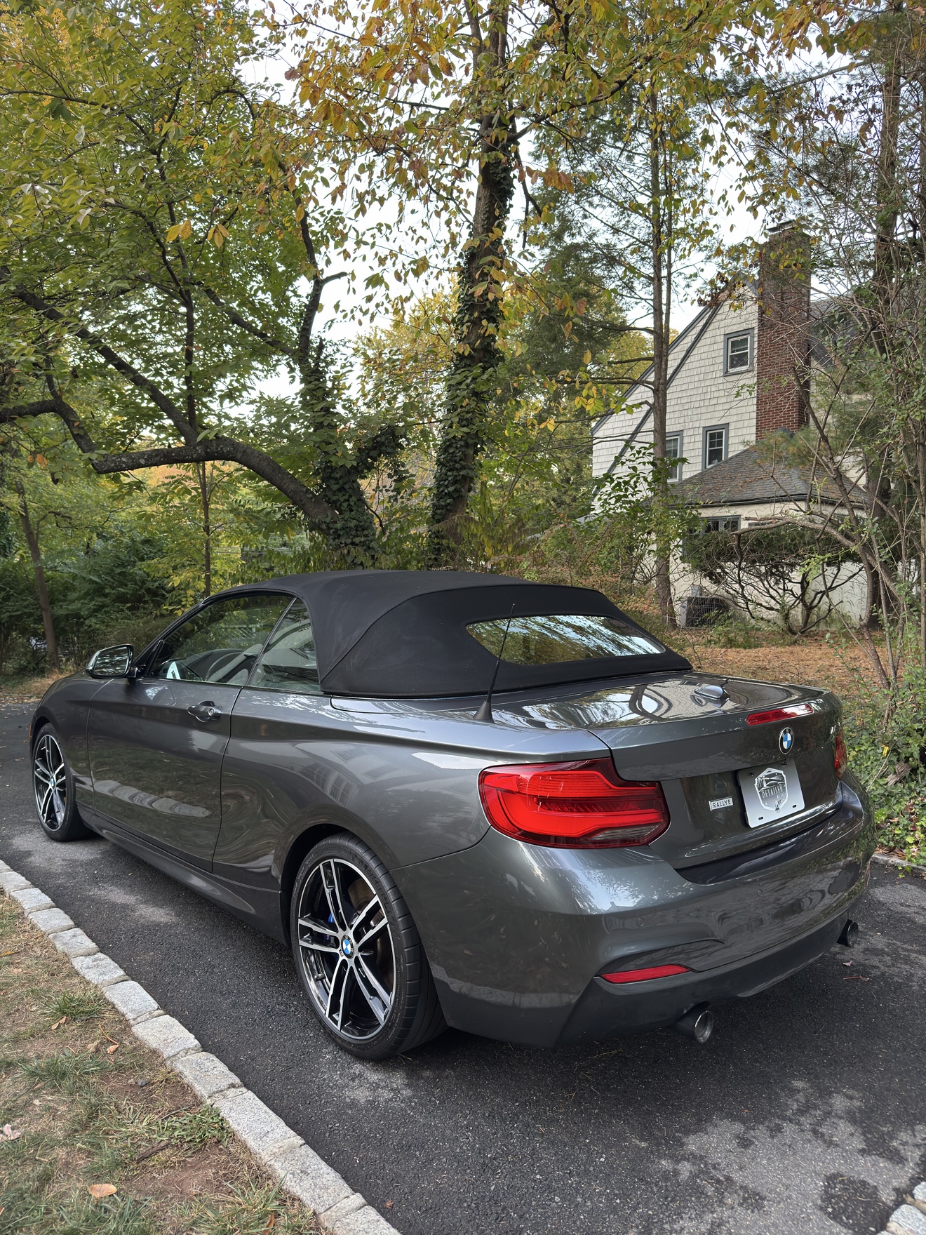 Gray BMW M240i convertible rear angle view after detailing