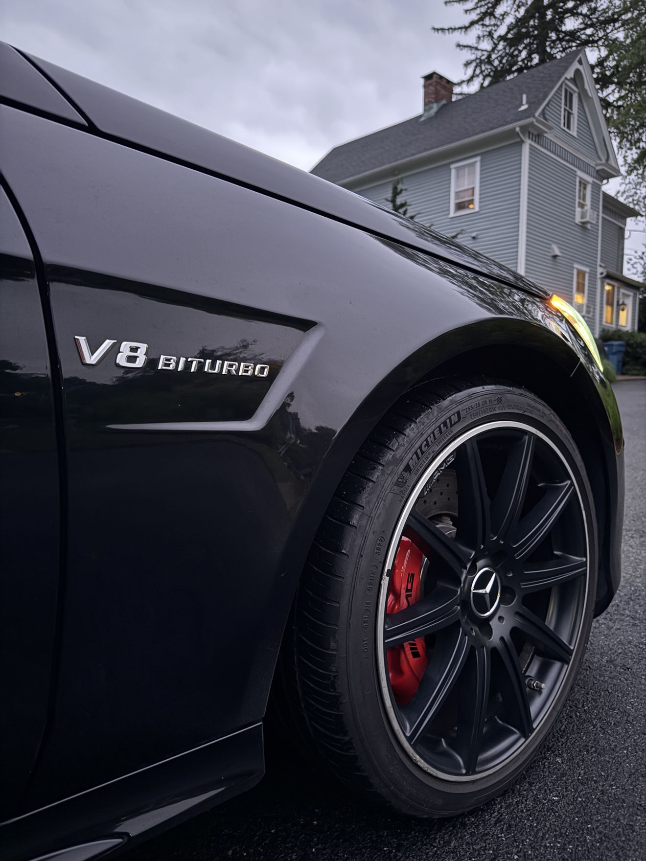 Close-up of the V8 Biturbo badge and AMG wheel on a black Mercedes Benz E63 S AMG wagon
