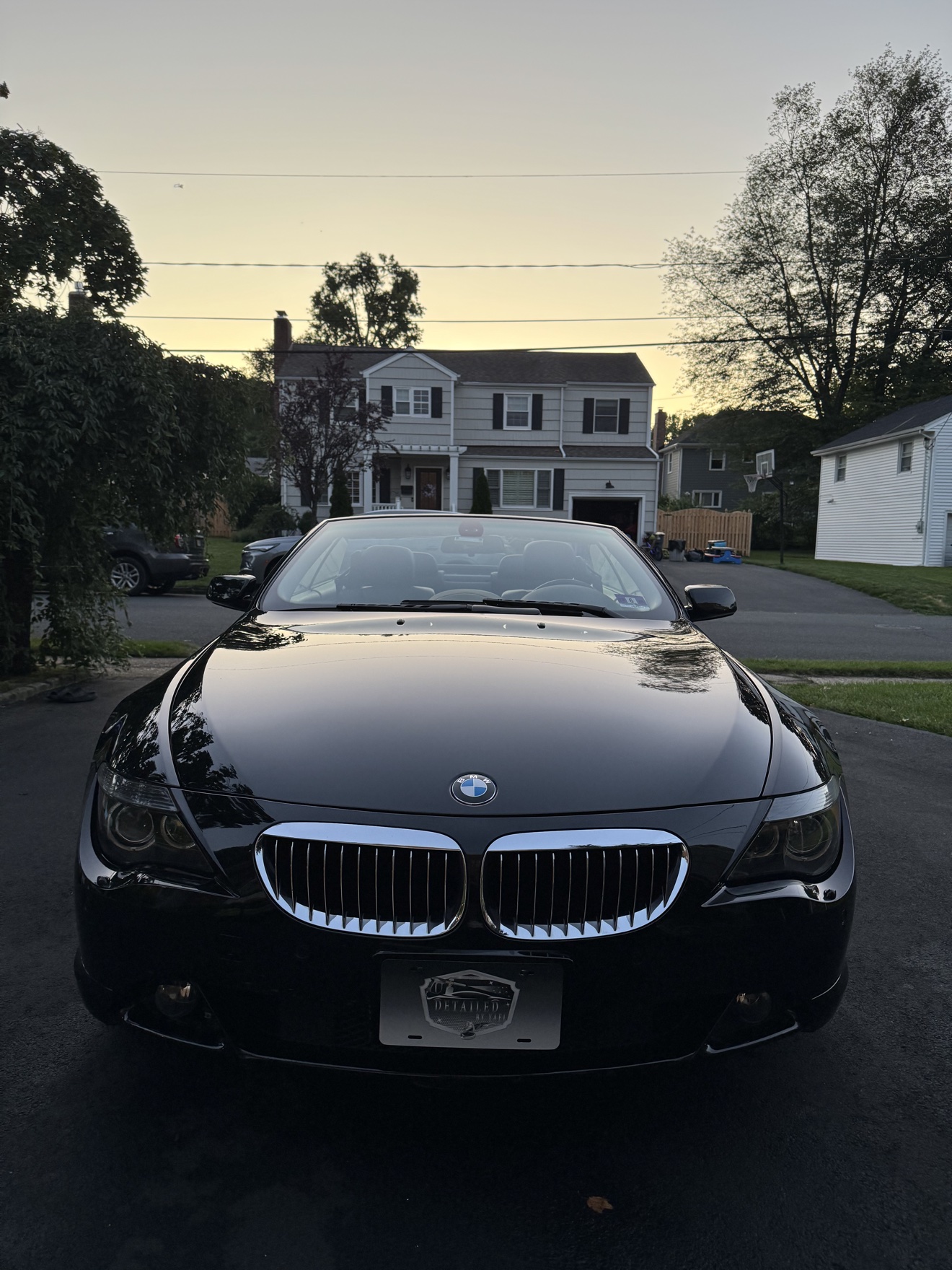 Front view of a black BMW 650i convertible with Detailed by Yael plate frame