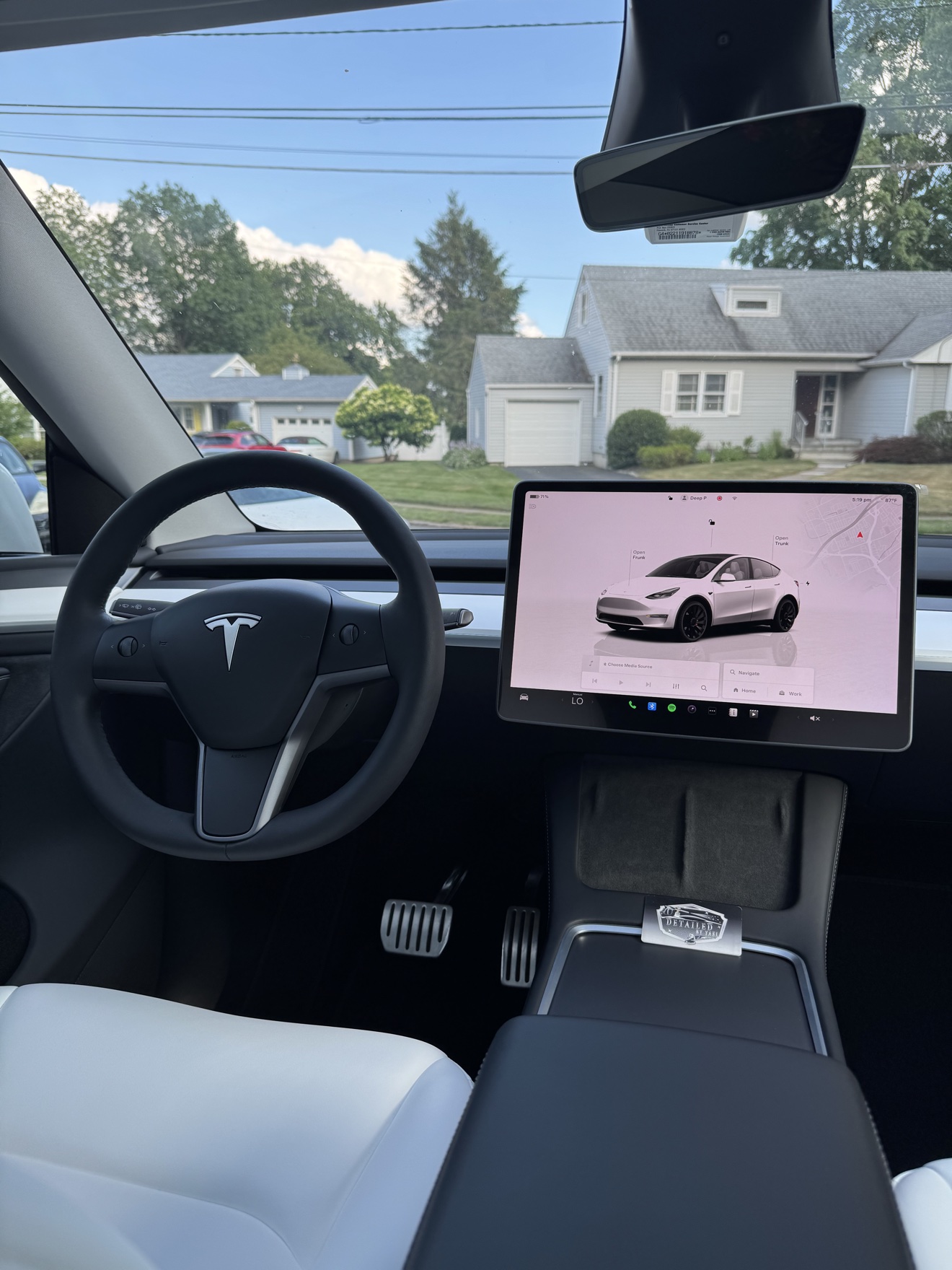 Tesla Model Y dashboard with display screen and Detailed by Yael business card