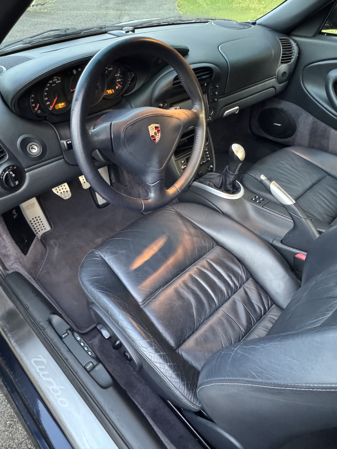 Porsche 911 Turbo driver cockpit with black leather interior, manual shifter and turbo sill plate