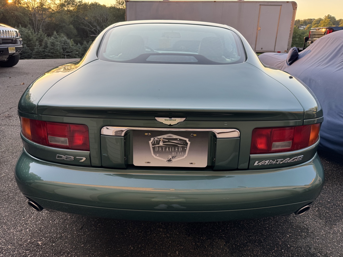 Rear view of a green Aston Martin DB7 Vantage with DB7 and Vantage badges and Detailed by Yael plate frame