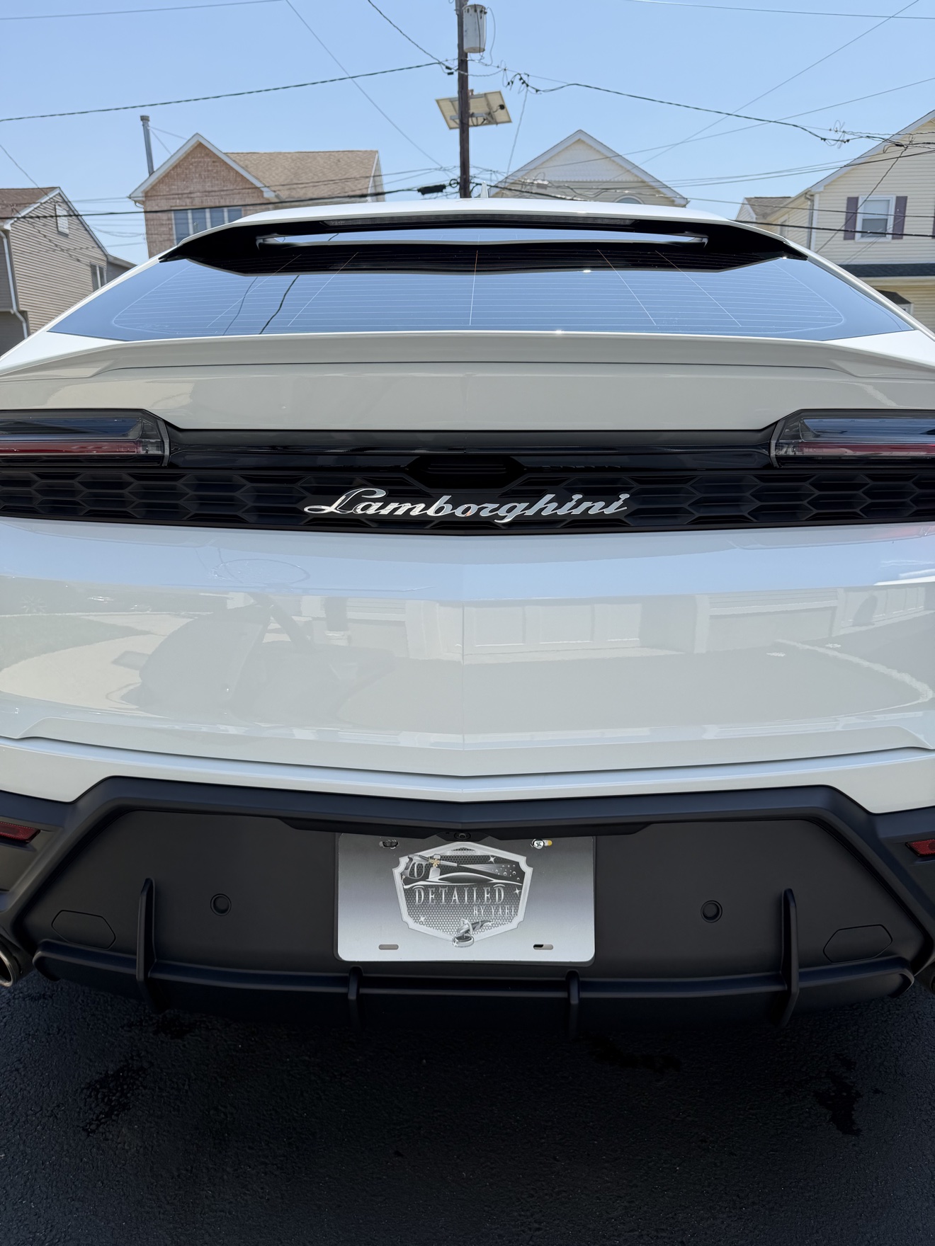 Close-up of Lamborghini badge on the rear of a white Urus