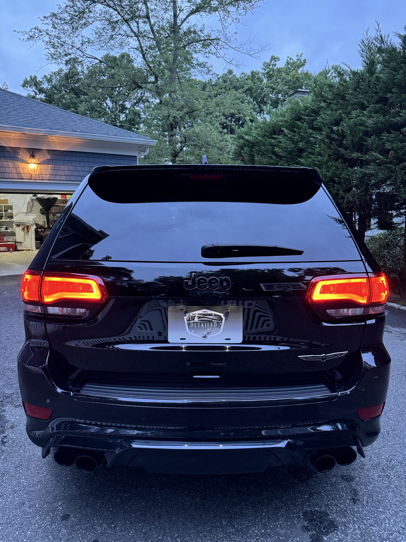 Rear view of a black Jeep Grand Cherokee Trackhawk with Detailed by Yael plate frame