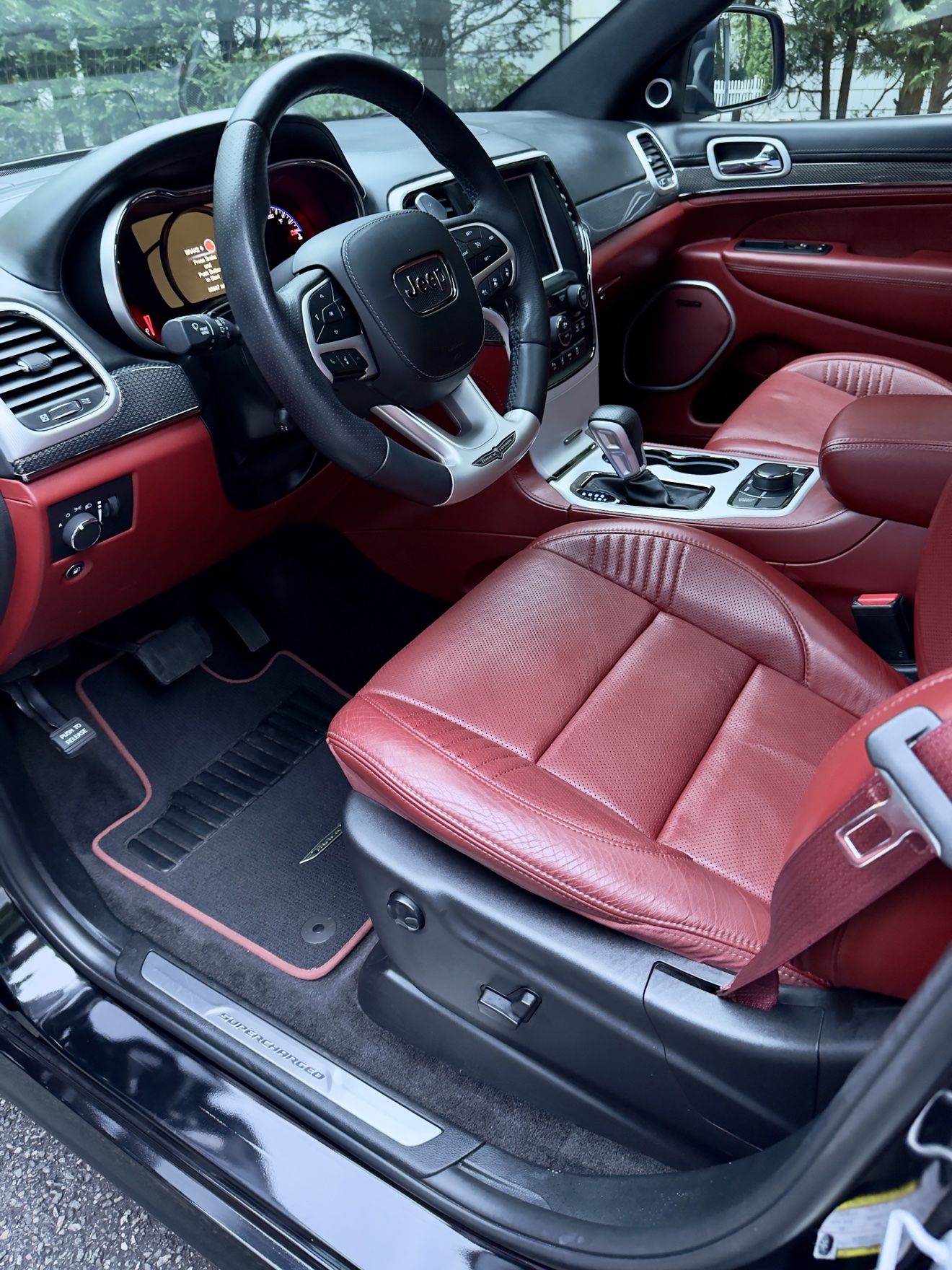 Trackhawk cockpit with red leather seats and supercharged sill plate after detailing
