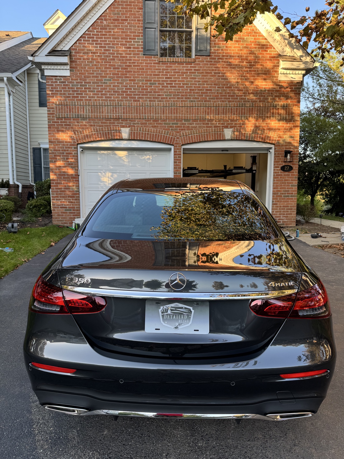 Rear view of a black 2023 Mercedes-Benz E350 4MATIC with Detailed by Yael plate frame