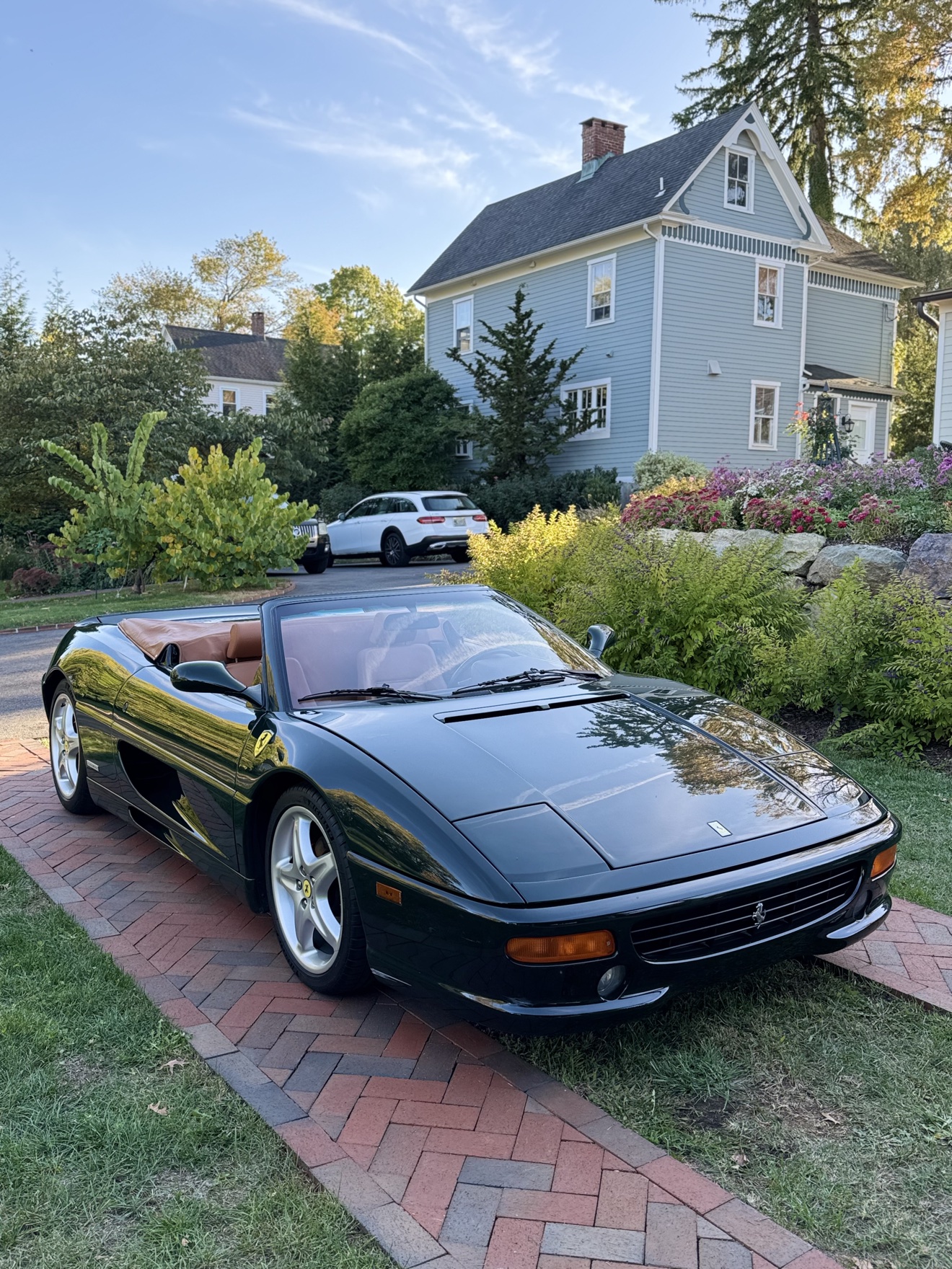 Dark green Ferrari F355 Spider front three-quarter view on a brick driveway