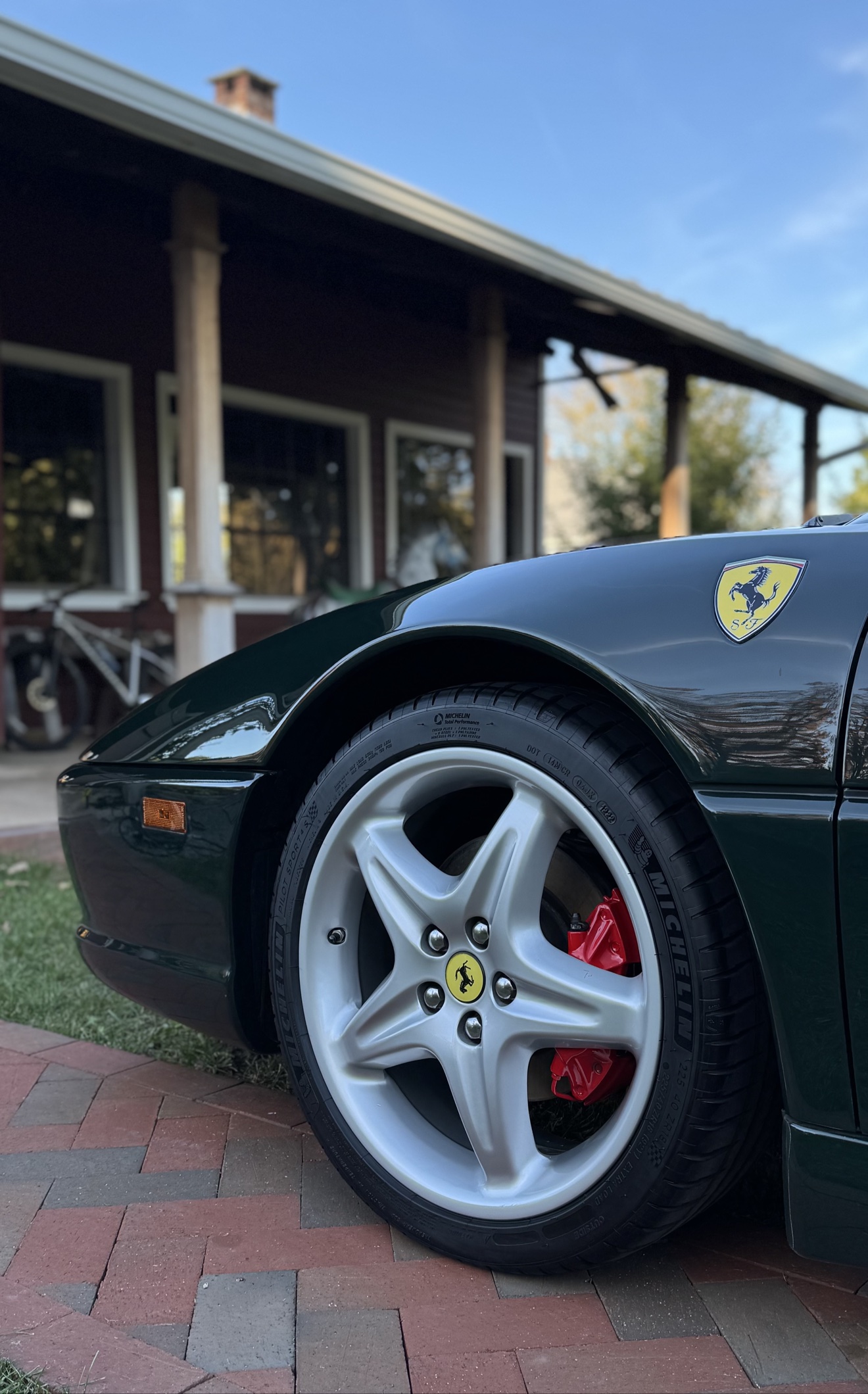 Close-up of the silver F355 Spider wheel with red brake caliper and Ferrari shield
